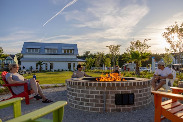 view of property's community with an outdoor fire pit and a lawn