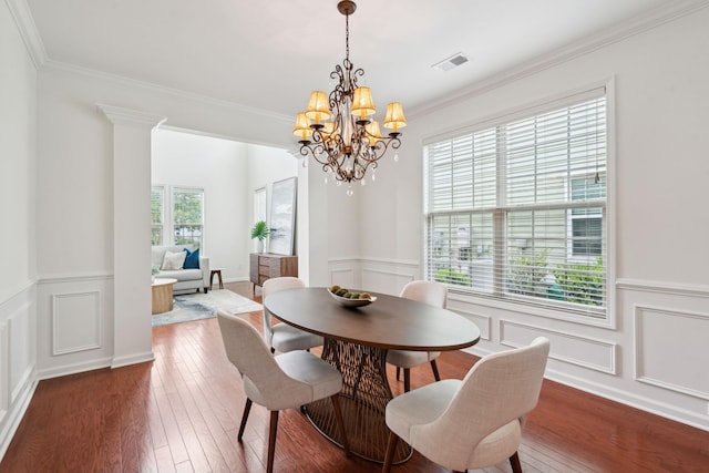 dining area with a decorative wall, a chandelier, ornamental molding, a wainscoted wall, and wood-type flooring