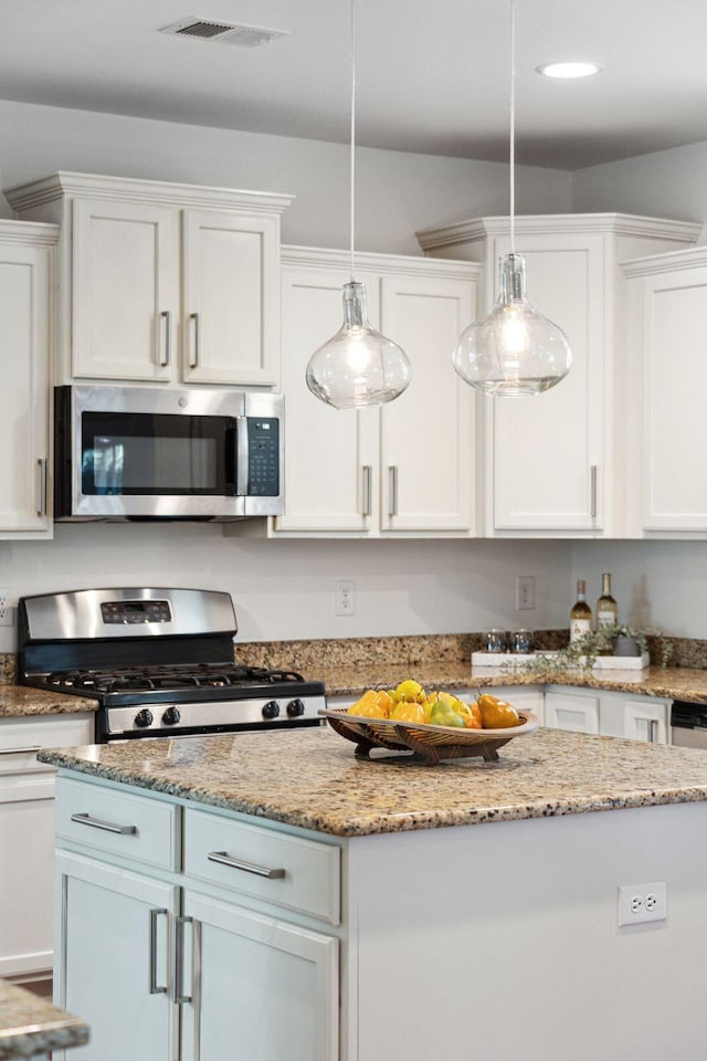 kitchen featuring stainless steel appliances, white cabinetry, decorative light fixtures, light stone counters, and recessed lighting