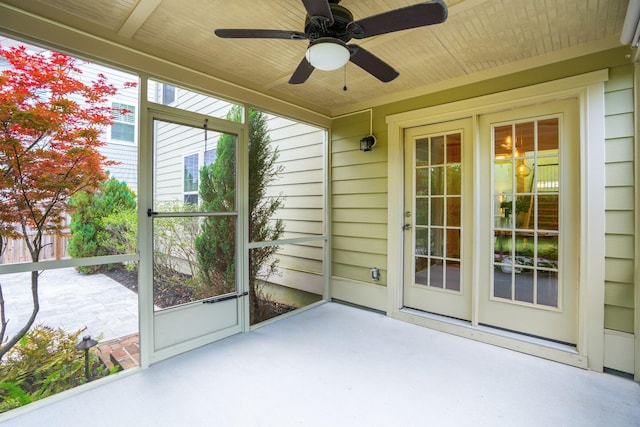 unfurnished sunroom with ceiling fan