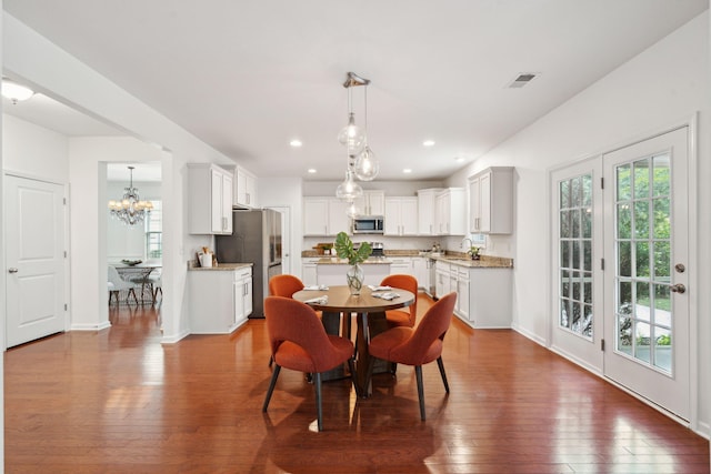 dining room with dark wood-type flooring, a chandelier, recessed lighting, and baseboards
