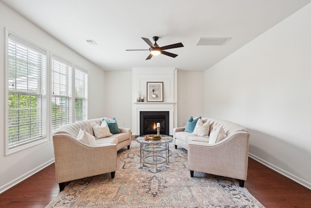 living room with baseboards, plenty of natural light, ceiling fan, and wood finished floors
