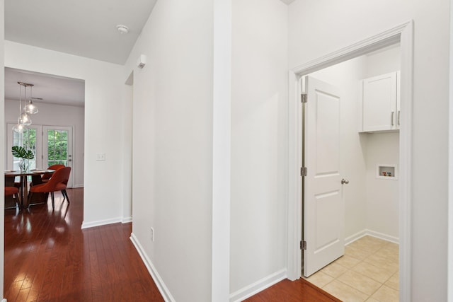 corridor with light wood-style floors and baseboards
