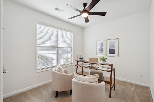office area featuring a ceiling fan, light colored carpet, and baseboards