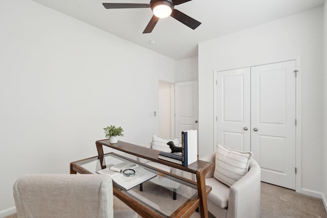 office with a ceiling fan, light carpet, and baseboards