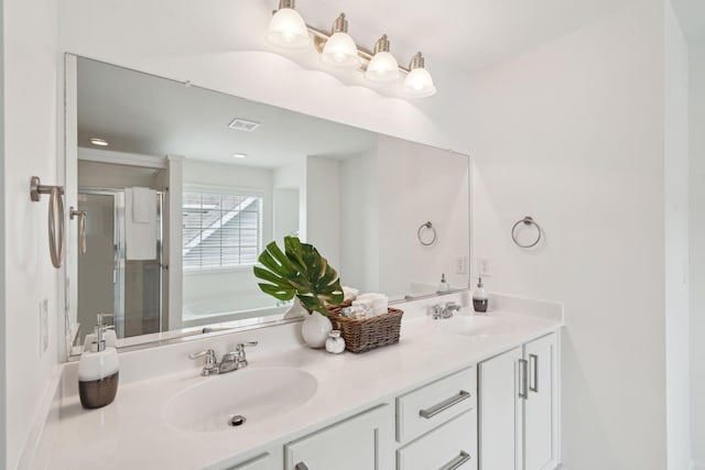 full bathroom with a sink, double vanity, a stall shower, and a garden tub