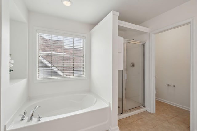 full bathroom featuring tile patterned floors, a garden tub, a wealth of natural light, and a shower stall
