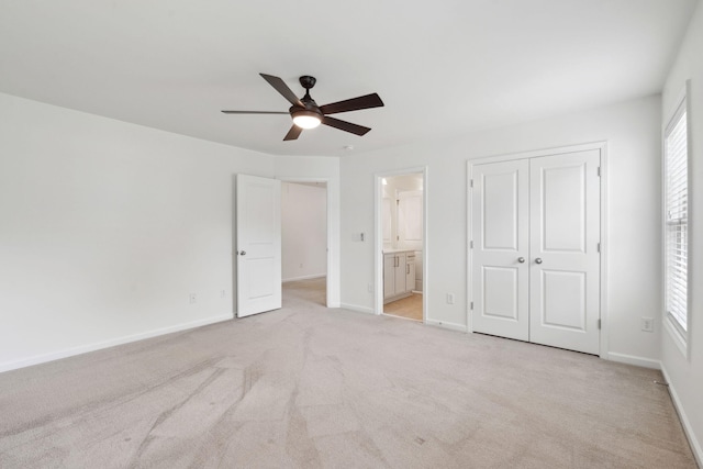 unfurnished bedroom with multiple windows, light carpet, and baseboards