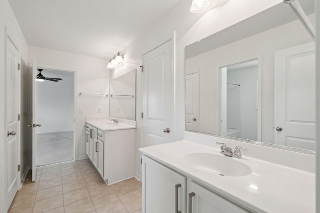 bathroom with ceiling fan, tile patterned flooring, two vanities, and a sink