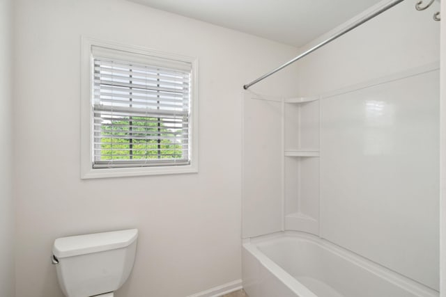 bathroom featuring toilet, baseboards, and bathtub / shower combination