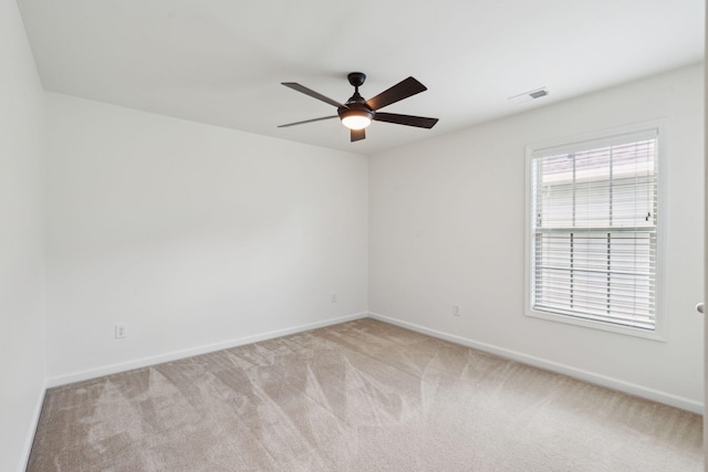 empty room with carpet, visible vents, baseboards, and ceiling fan