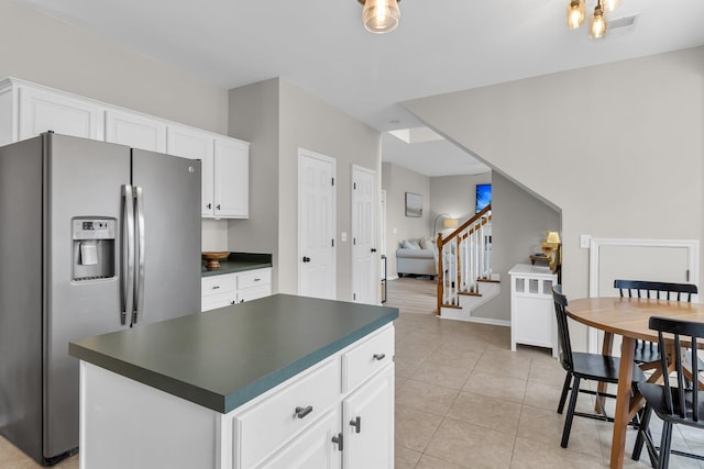 kitchen with white cabinetry, light tile patterned flooring, a center island, and stainless steel fridge with ice dispenser