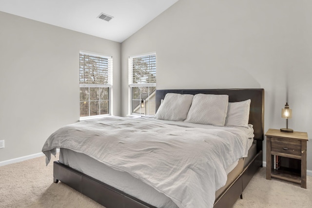 bedroom with vaulted ceiling and light carpet