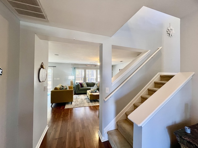 staircase featuring ceiling fan and hardwood / wood-style floors