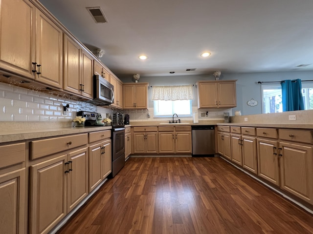 kitchen featuring sink, light brown cabinets, stainless steel appliances, dark hardwood / wood-style floors, and backsplash