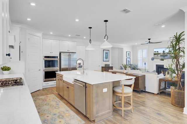 kitchen featuring visible vents, stainless steel appliances, light countertops, and a sink