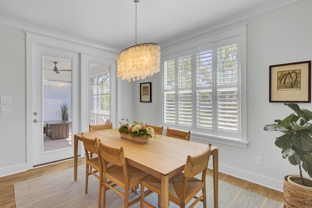 dining area featuring baseboards, wood finished floors, a notable chandelier, and plenty of natural light