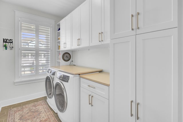 washroom featuring washing machine and dryer, cabinet space, tile patterned floors, and baseboards