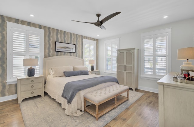 bedroom featuring baseboards, ceiling fan, and light wood-style floors