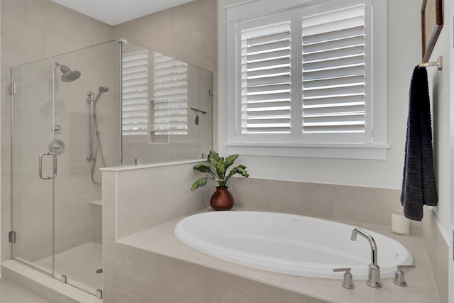 bathroom featuring a shower stall and a bath