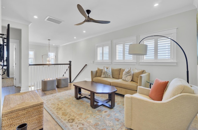 living area featuring visible vents, ceiling fan, a wealth of natural light, and wood finished floors