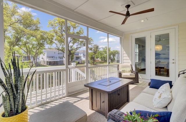 sunroom featuring a residential view, outdoor lounge area, and ceiling fan