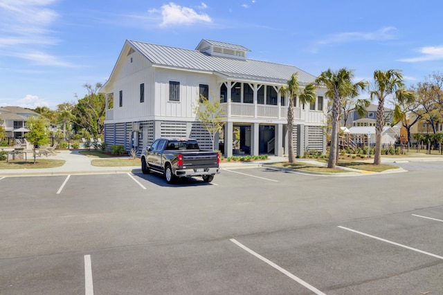 view of property featuring uncovered parking and stairs