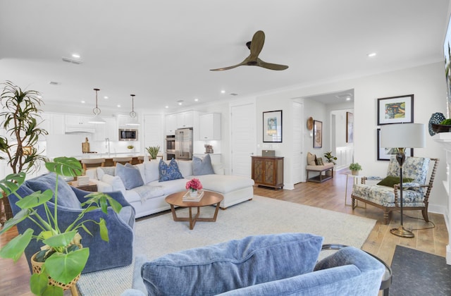 living room featuring light wood-style floors, recessed lighting, visible vents, and a ceiling fan