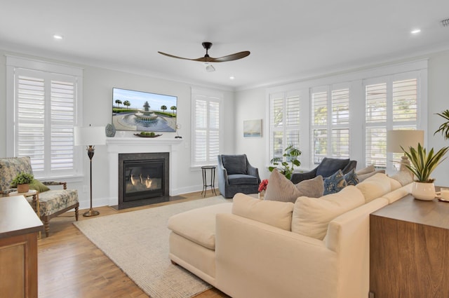 living room featuring recessed lighting, a fireplace with flush hearth, a ceiling fan, visible vents, and wood finished floors