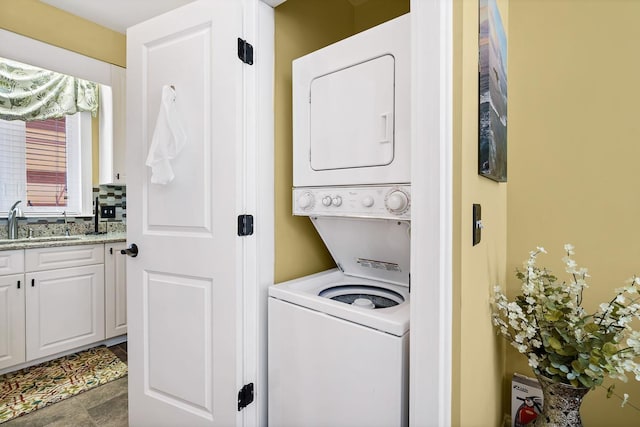 washroom with sink and stacked washer and dryer