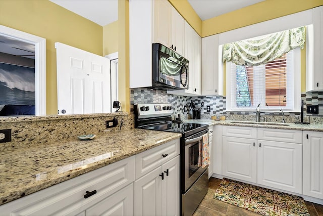 kitchen featuring decorative backsplash, white cabinets, electric range, light stone countertops, and sink