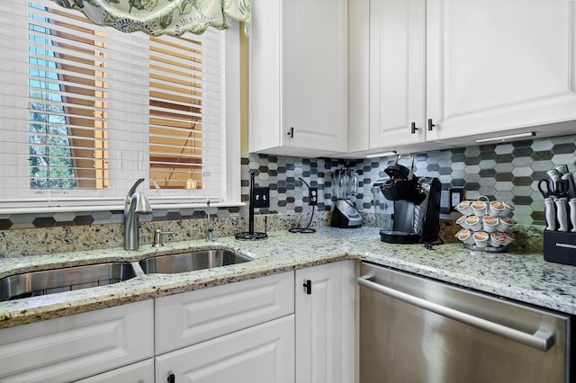 kitchen featuring light stone countertops, sink, dishwasher, backsplash, and white cabinetry