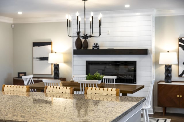 1762 James Loop Rd, Manning, SC 29102 - kitchen featuring a chandelier, ornamental molding, recessed lighting, a glass covered fireplace, and dark wood-style flooring