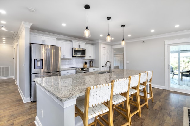 1762 James Loop Rd, Manning, SC 29102 - kitchen featuring appliances with stainless steel finishes, a sink, decorative backsplash, dark wood-type flooring, and a kitchen island with sink