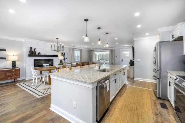 1762 James Loop Rd, Manning, SC 29102 - kitchen with appliances with stainless steel finishes, a sink, crown molding, white cabinetry, and a center island with sink