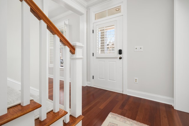 foyer featuring crown molding, stairs, baseboards, and wood finished floors