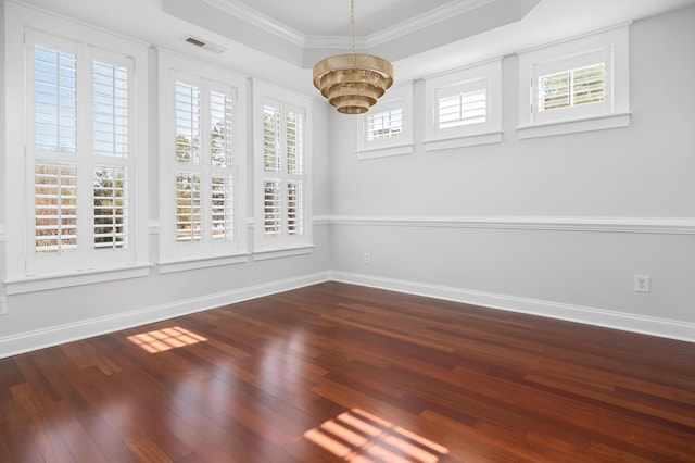 spare room featuring visible vents, a raised ceiling, dark wood-style floors, and a chandelier