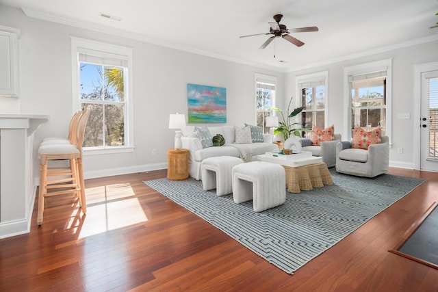 living room featuring visible vents, ornamental molding, ceiling fan, and wood-type flooring