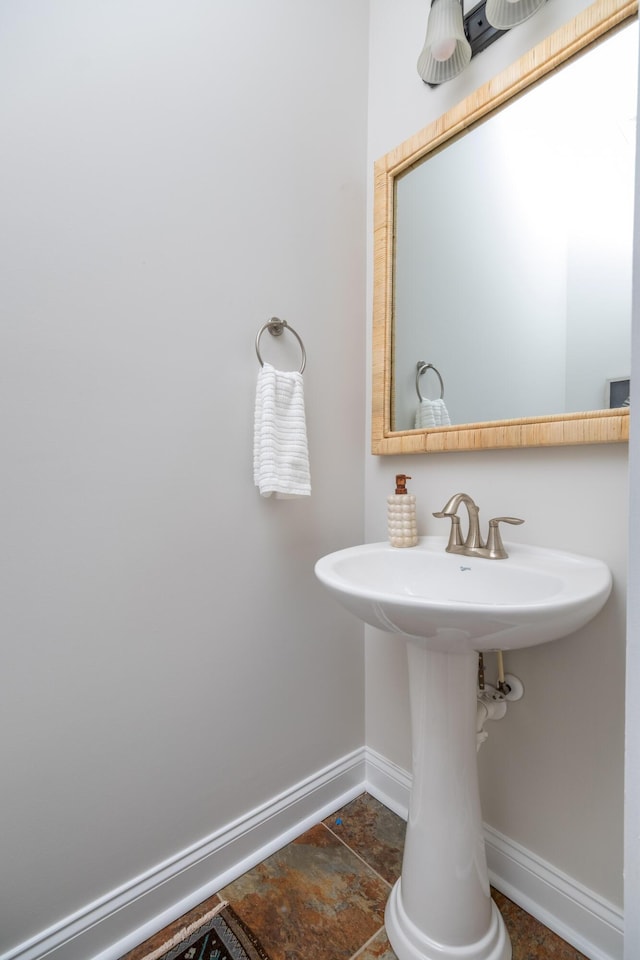 bathroom featuring baseboards and a sink