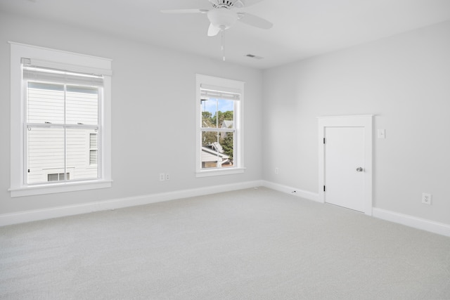 spare room with visible vents, light carpet, baseboards, and ceiling fan