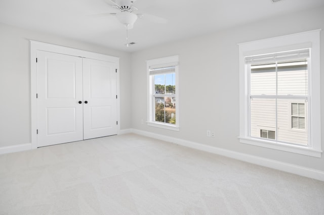 unfurnished bedroom with visible vents, baseboards, a closet, and light carpet