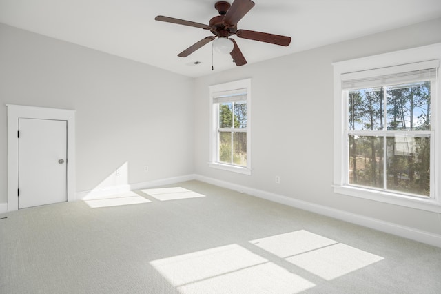 spare room with carpet flooring, baseboards, and visible vents