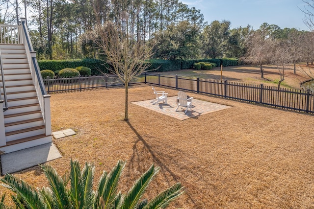 view of yard with a patio, stairs, and a fenced backyard