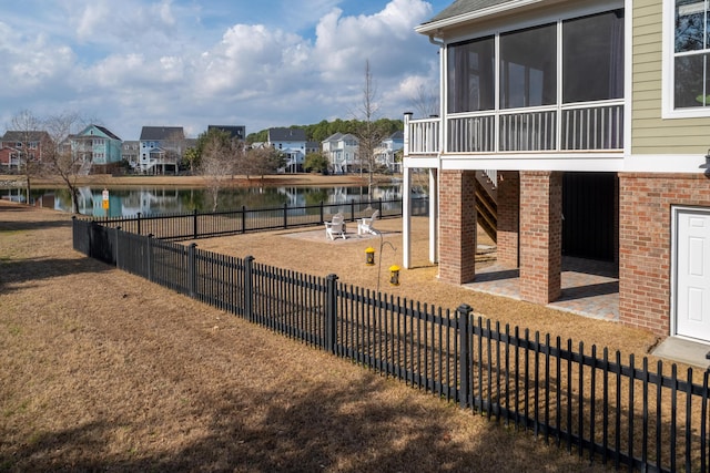 view of yard with a residential view, a patio, fence private yard, and a water view