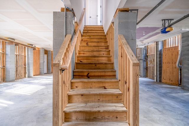 stairway featuring unfinished concrete floors