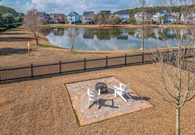 view of yard featuring a residential view, fence, a patio, and a water view