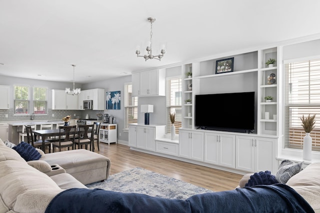 living area featuring a chandelier and light wood-style flooring