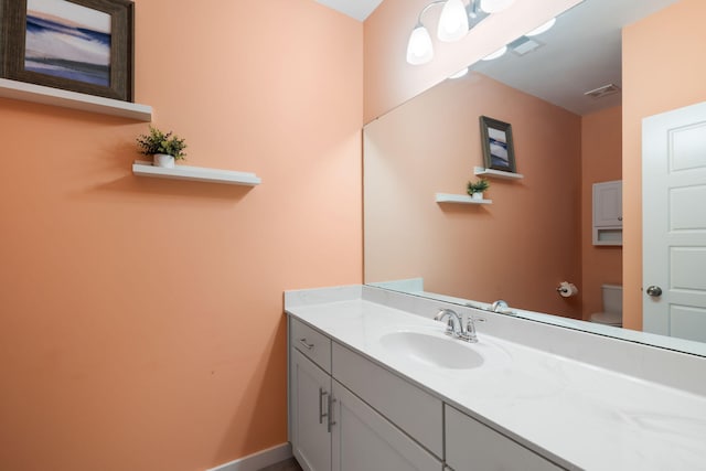 half bathroom featuring vanity and toilet