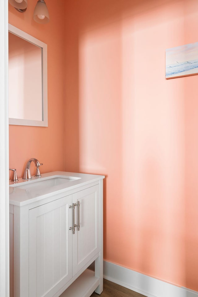 bathroom featuring vanity, baseboards, and wood finished floors