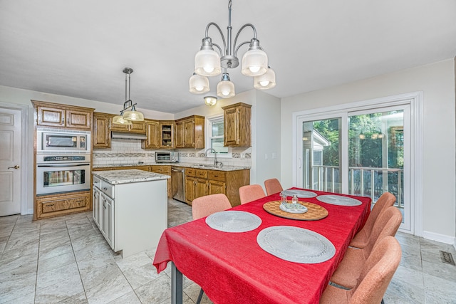 dining space featuring light tile patterned flooring, sink, and a notable chandelier